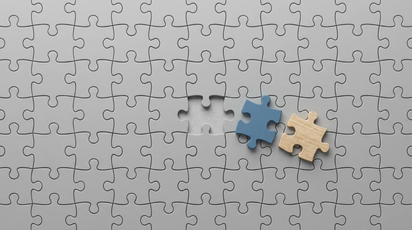 Flat lay of an incomplete puzzle with a gap and two different pieces.