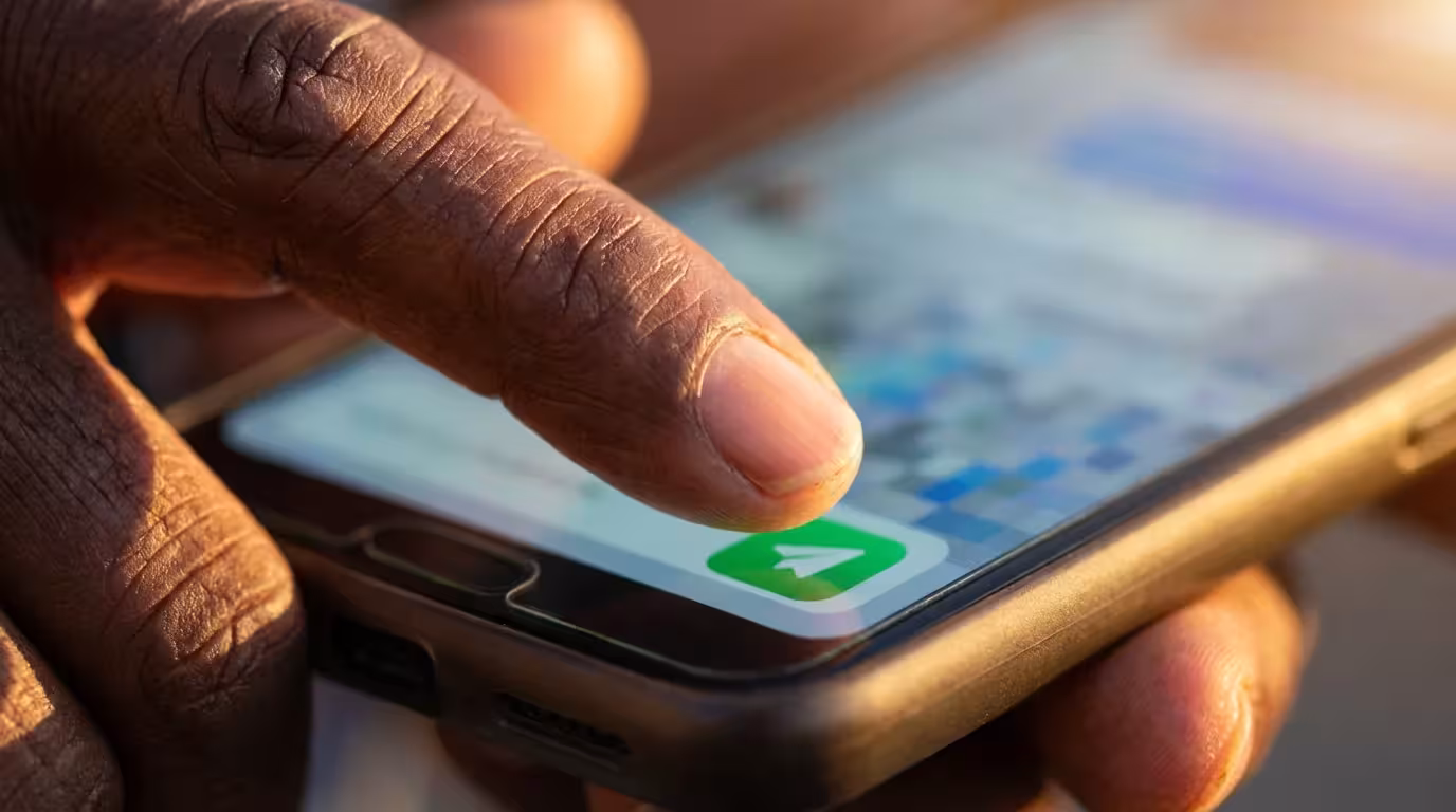 Macro photo of a senior's finger about to tap 'send' on a smartphone.